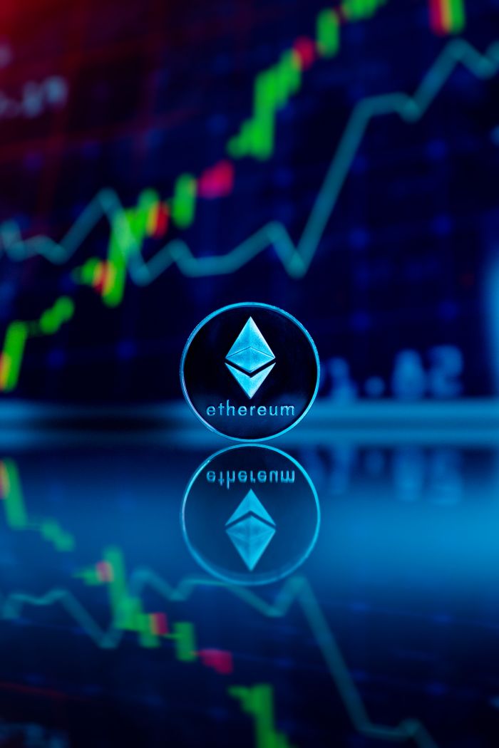 Ethereum coin reflecting with financial graph in the background, symbolizing digital currency trading.